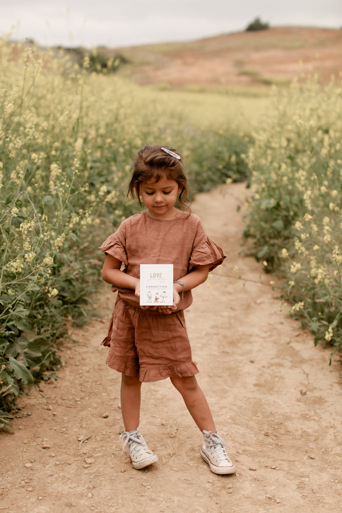 Photo of child outside holding an affirmation card
